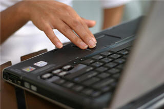 Woman's hand over a laptop touch pad.