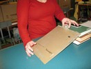 Photo of a student rolling a ball down a cardboard ramp.