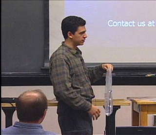 Student showing a clear plastic bag with hose and nozzle.