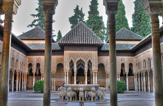 Couryard with columns and statues of lions in the center.