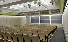 A lecture hall, looking from the rear of the room toward the lectern and blackboards.