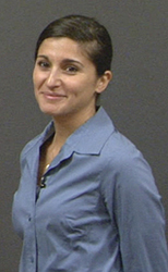 Headshot of a young woman in a blue colloared shirt..