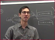 A men standing in front of a blackboard and facing front.