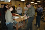 Instructor Tony Dias demonstrates layout of hull shape on a wood block prior to the first cut.