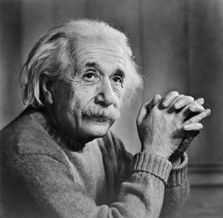 A photograph of Albert Einstein sitting at a table.