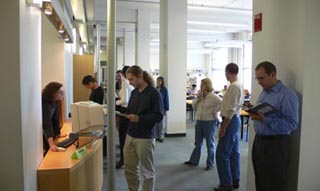 Library patrons standing before a desk.