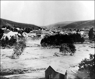 A photogrpah of a flash flood ravaging a town.