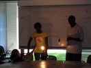 Students hold up a piece of paper to a lit lightbulb.